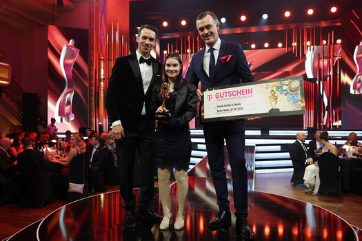Auf dem Foto stehen Felix Neureuther, Sophie Dziadek und der Geschäftsführer von Special Olympics Deutschland. Er hält einen Gutschein in der Hand. Sophie Dziadek hält eine Trophäe in der Hand. Das Foto wurde bei der Preisverleihung in Baden-Baden gemacht. Foto: Alexander Hassenstein