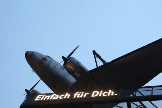 Auf dem Foto ist blauer Himmel und ein Ausschnitt von einem Propeller-Flugzeug. Darunter steht: Einfach für dich. Foto: David Permantier
