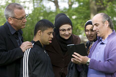 Eine Gruppe von Menschen schaut auf ein Smartphone (Foto: Florian von Ploetz)